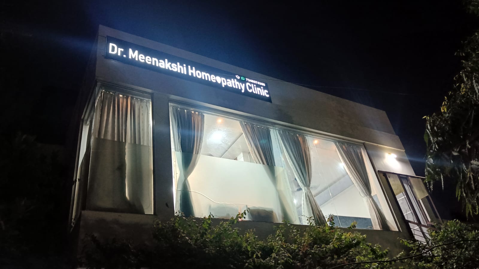 Dr. Meenakshi Homeopathy Clinic — illuminated signboard at night